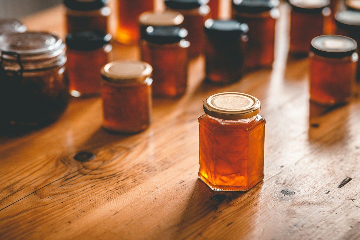 Bocaux de confiture orangée alignés sur une table en bois