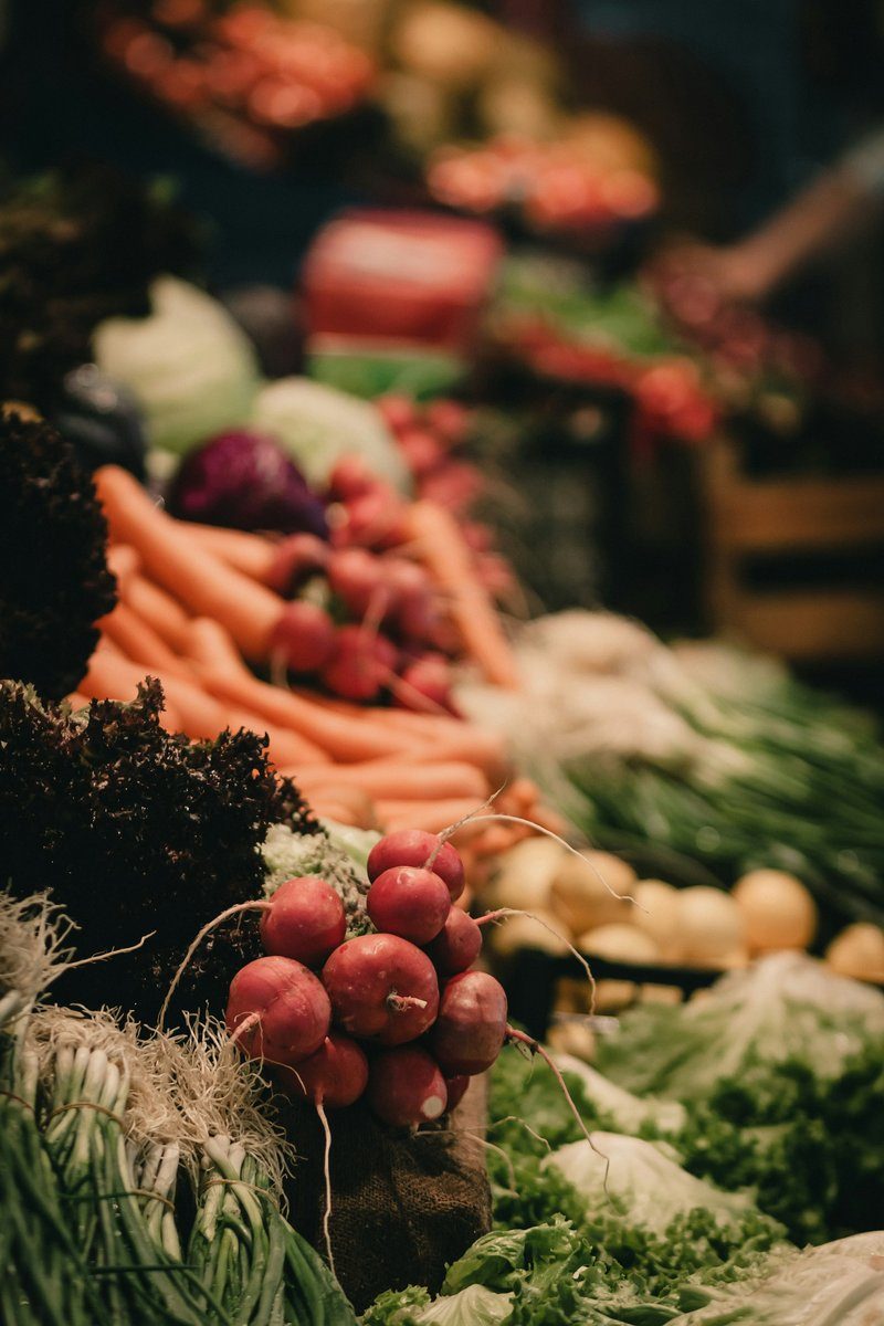 Étal de marché garni de carottes, de bottes de radis et de légumes verts