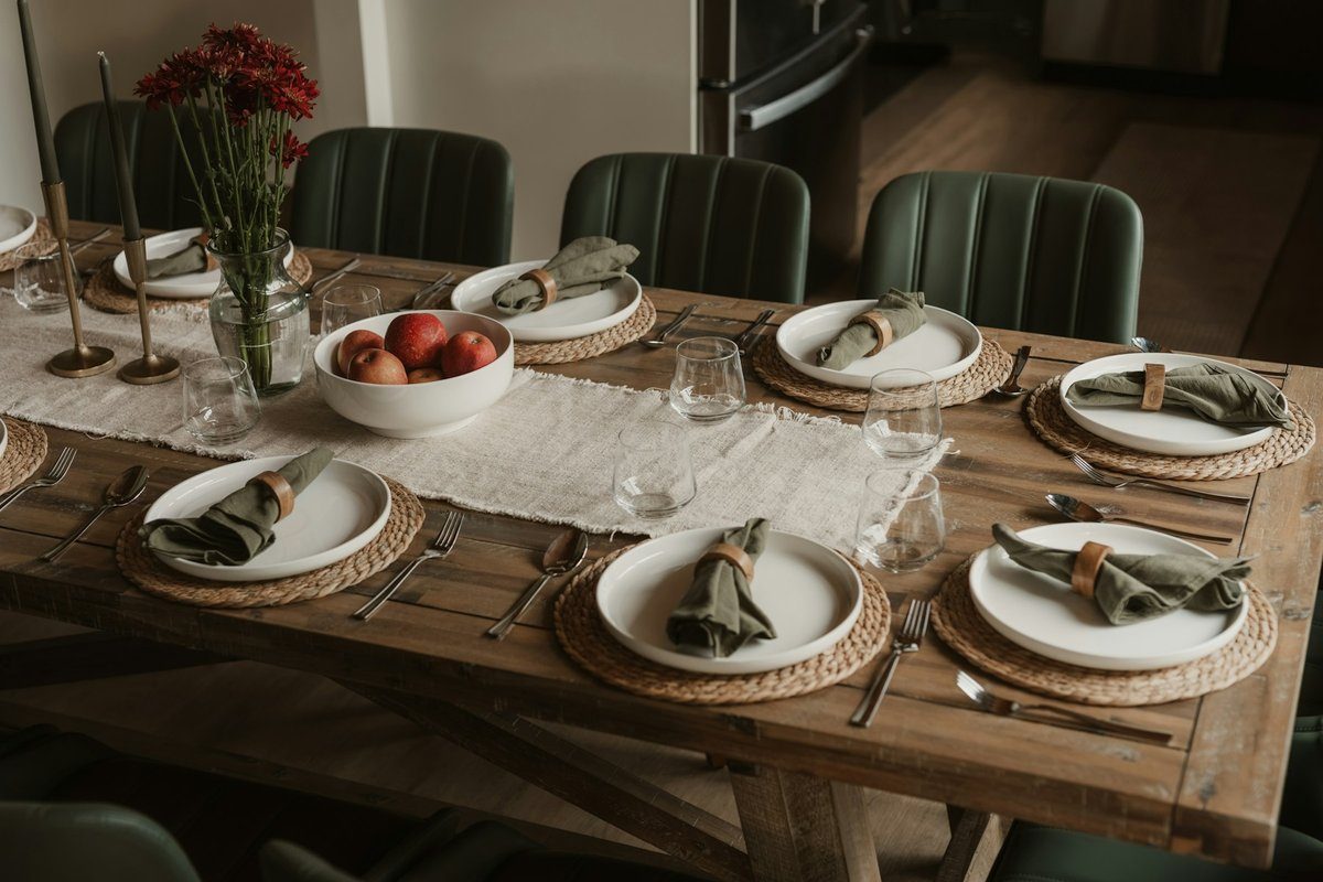 Table en bois dressée avec serviettes nouées et coupe de pommes au centre